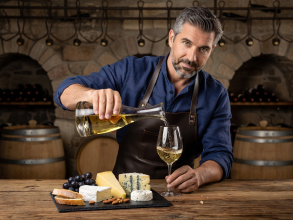 Sommelier pouring pairing beverage next to cheese flight